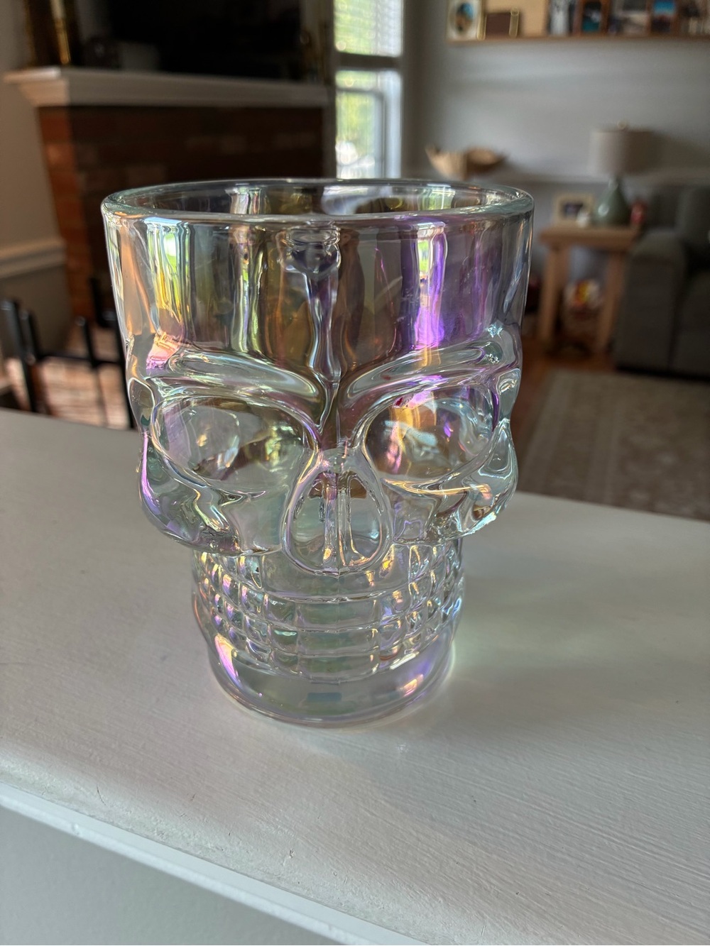 This is a clear glass skull mug featuring an iridescent, rainbow pearl luster